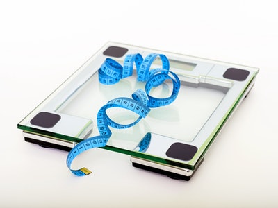 blue-tape-measuring-on-clear-glass-square-weighing-scale-53404